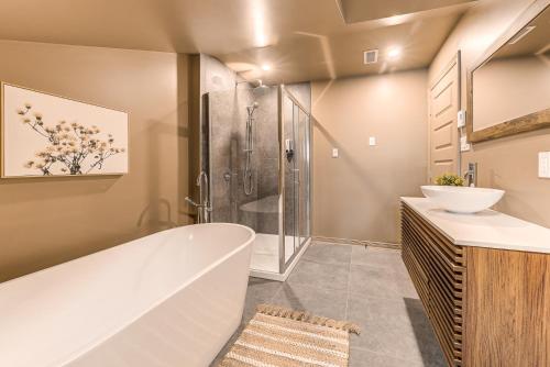 a bathroom with a tub and a sink and a shower at St. Ursule Two-Storey Oasis in Quebec City