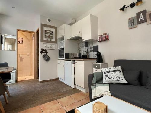 un salon avec un canapé et une cuisine dans l'établissement Maisonnette cosy 3* avec terrasse au calme, proche centre-ville et thermes d'Aix-les-Bains - FR-1-555-95, à Aix-les-Bains