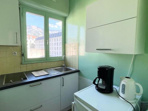 une petite cuisine avec un évier et une fenêtre dans l'établissement Studio lumineux avec balcon et parking - Animaux acceptés - FR-1-555-93, à Aix-les-Bains