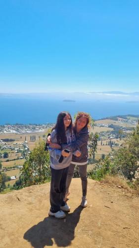 two girls standing on top of a hill at PARCELA DE AGRADO CON PISCINA LAGO RANCO todas las instalaciones con uso exclusivo capacidad 20 personas in Lago Ranco