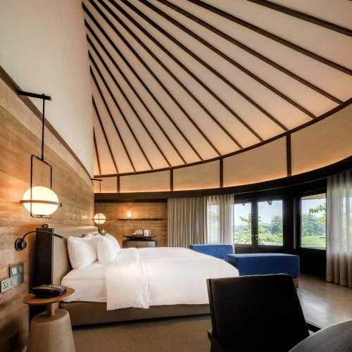 a bedroom with a large white bed and a desk at Patamma Hideaway Resort in Nan