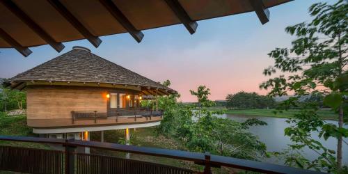 a building with a roof next to a river at Patamma Hideaway Resort in Nan