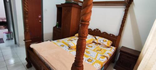 sypialnia z łóżkiem z drewnianą ramą w obiekcie Homestay Kluang 309 