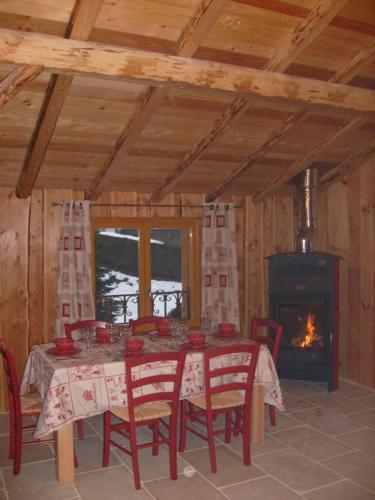 a dining room with a table and a fireplace at Chalets Julien in Le Thillot