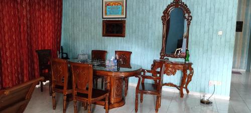 stół jadalny z krzesłami i lustrem w obiekcie Homestay Kluang 309 