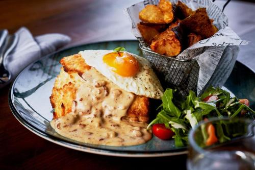 a plate of food with an egg and a salad at The Union Station Nashville Yards, Autograph Collection in Nashville