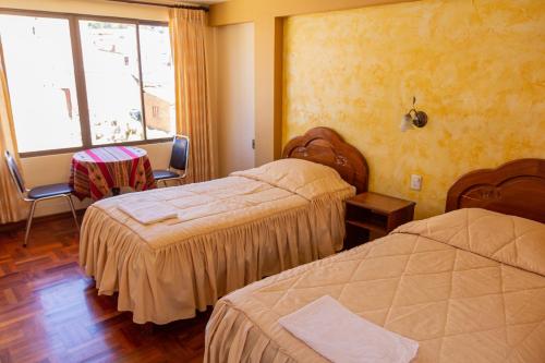 a hotel room with two beds and a window at Hostal Sonia in Copacabana