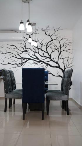 a dining room with a tree mural on the wall at Paramount 3-Bedroom Apartment with Parking in San Felipe de Puerto Plata
