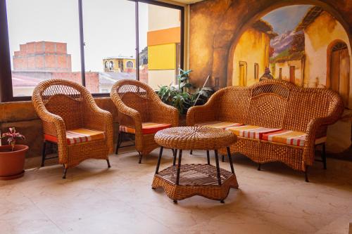 a group of wicker chairs and tables in a room at Hostal Sonia in Copacabana