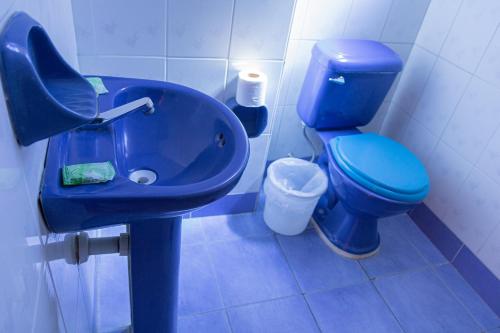 uma casa de banho com um WC azul e um lavatório. em Hostal Sonia em Copacabana