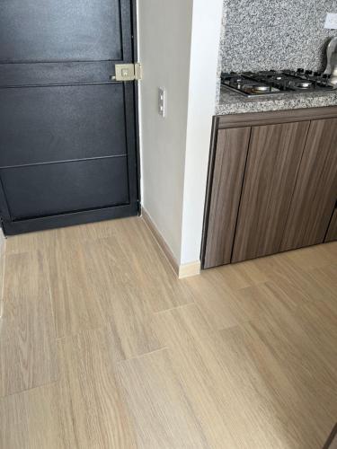 a kitchen with a stove and a wooden floor at Apartamento Cómodo en Girardot Cundinamarca in Girardot