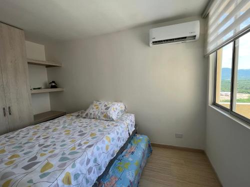 a small bedroom with a bed and a window at Apartamento Cómodo en Girardot Cundinamarca in Girardot