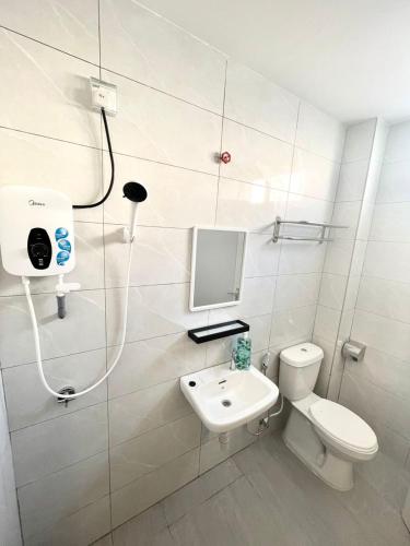 y baño con aseo, lavabo y ducha. en Garden Inns Motel en Kangar