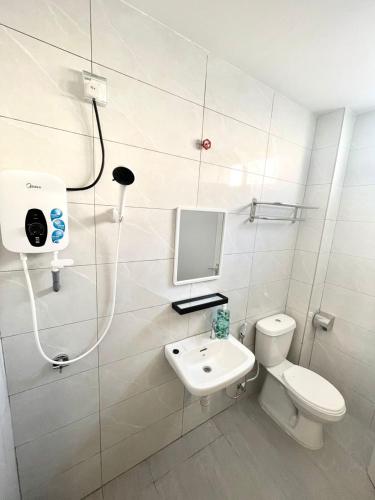 a bathroom with a toilet and a sink and a shower at Garden Inns Motel in Kangar