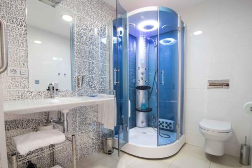 y baño con ducha, aseo y lavamanos. en RuralSuite Hotel Apartamentos, en Cascante