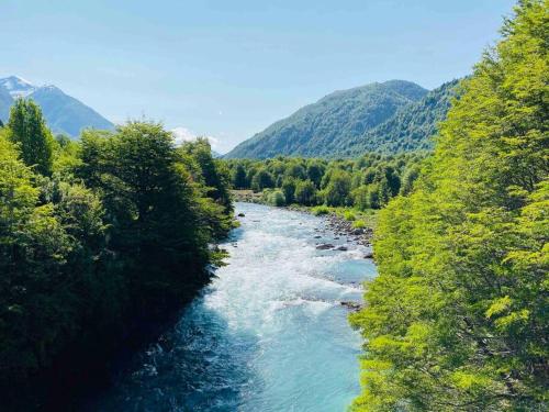 a river with green trees on the side of it at Tierra Azul ....Aires de cordillera. in Arrayán