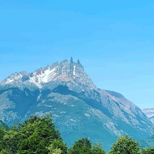 a snow covered mountain with trees in front of it at Tierra Azul ....Aires de cordillera. in Arrayán