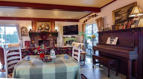 a living room with a table and a piano at The Hazelhouse in Chilliwack