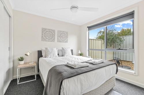 um quarto com uma cama e uma grande janela em Stylish and Spacious Launceston Villa + Free Wifi em Launceston