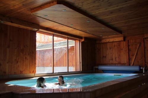 a man and a woman in a hot tub at Chalets Julien in Le Thillot