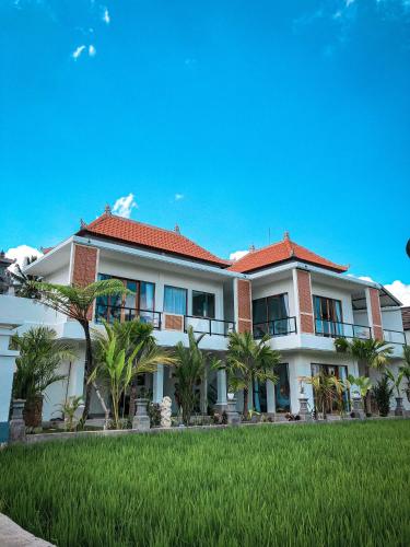 un gran edificio blanco con palmeras delante en Kemala Hospitality, en Tegalalang