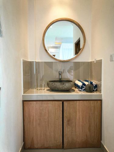 ein Bad mit einem Waschbecken und einem Spiegel in der Unterkunft Kemala Hospitality in Tegalalang