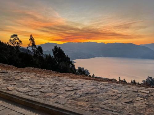 a view of a lake at sunset from a mountain at Pacucha Glamping in Andahuaylas
