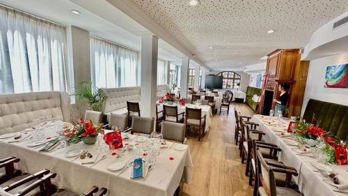 a dining room with tables and chairs with flowers on them at Hôtellerie Du Bas-Bréau in Barbizon