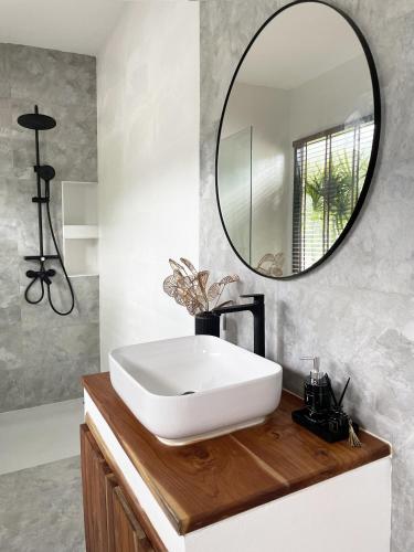 a bathroom with a white sink and a mirror at Infinity Villa in Salad Beach