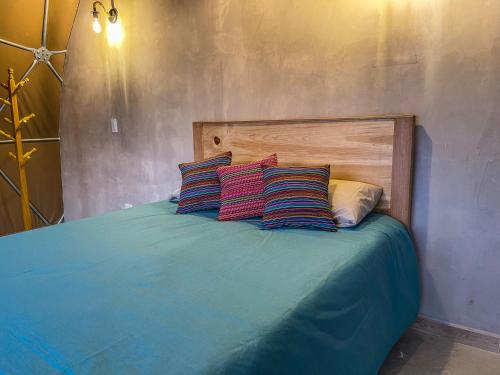 a bed with two colorful pillows on top of it at Pacucha Glamping in Andahuaylas