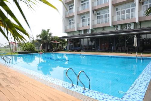 a large swimming pool in front of a building at J&C HOTEL in Bắc Ninh