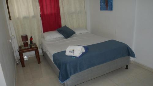 a small bedroom with a bed and a window at Guacamayas in Santa Marta