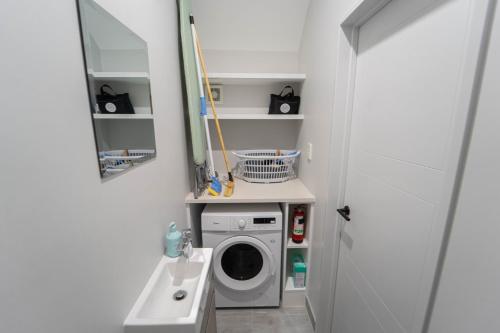 a laundry room with a washing machine and a sink at Modern Sunnyhills Town House in Auckland
