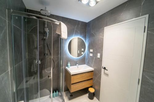 a bathroom with a shower and a sink and a mirror at Modern Sunnyhills Town House in Auckland