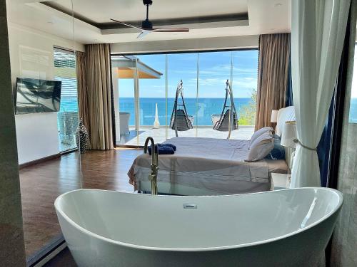 a bath tub in a room with a bed at 苏梅岛观景台海景別墅Golden Coconut Villa 5 超级海景 私密泳池 接送服务 in Koh Samui 