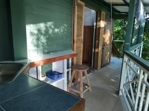 un taburete sentado en el porche delantero de una casa en Frente al mar APARTO STUDIO BLUE LIZARD, en Providencia