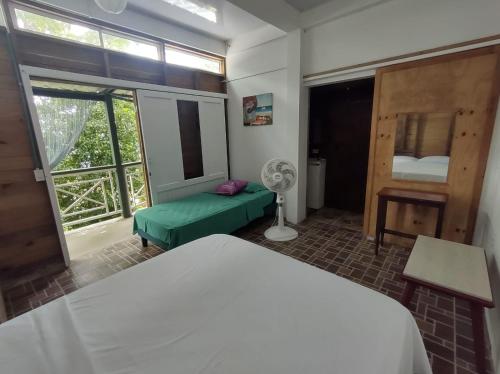 1 dormitorio con 1 cama y ventana con ventilador en Frente al mar APARTO STUDIO BLUE LIZARD, en Providencia
