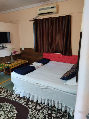 a bedroom with a large bed with a window at Visava Cottages Kihim Beach in Kīhīm