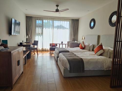 - une chambre avec un grand lit et un bureau dans l'établissement 七星海快乐主屋度假酒店, à Kaoh Sdach