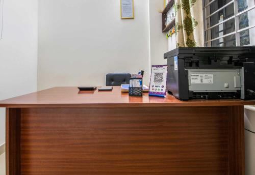 a desk with a microwave and a computer on it at Hotel O Sagar Comforts in Bengaluru
