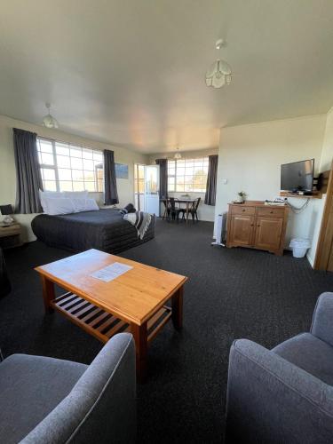 a living room with a couch and a coffee table at Colonial Motel in Twizel