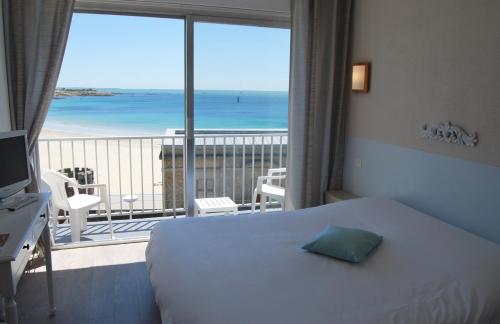 ein Schlafzimmer mit Bett und Blick auf das Meer in der Unterkunft Hôtel des Druides in Quiberon