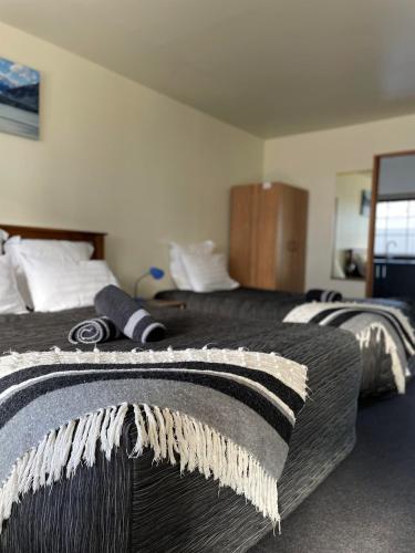 a hotel room with two beds with blankets on them at Colonial Motel in Twizel