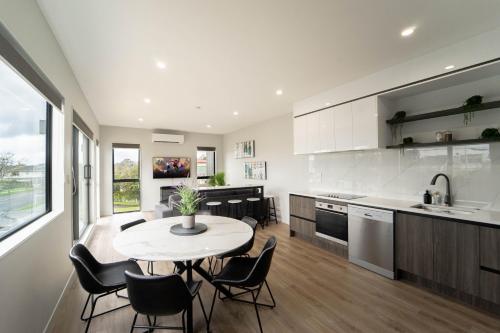 a kitchen and dining room with a table and chairs at Sunnyhills Viewside Town House in Auckland