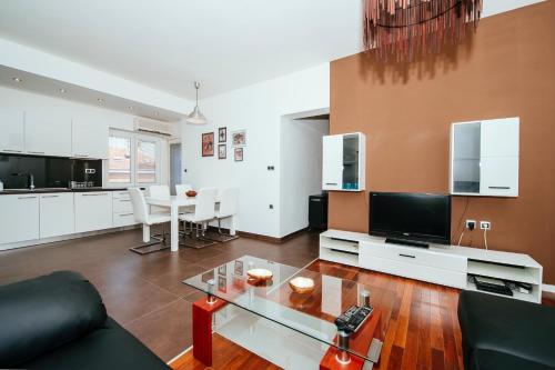 un soggiorno con divano e tavolo in vetro di Golden Bridge Apartment with private parking a Zara (Zadar)