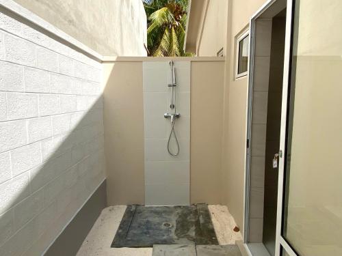 a shower in a bathroom with a glass door at TME Retreats Dhigurah in Dhigurah
