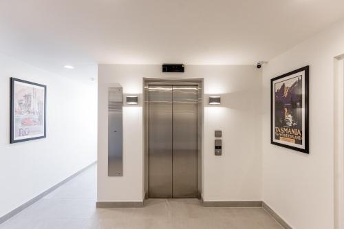 a elevator in a building with two pictures on the wall at Little Island Apartments in Hobart