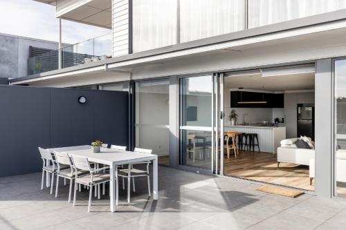 a kitchen and dining room with a table and chairs at Little Island Apartments in Hobart