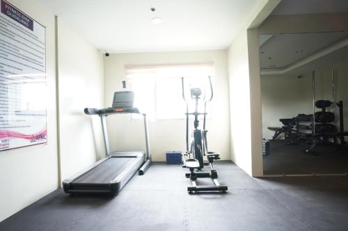a room with a gym with a treadmill and weights at Modern Designed Studio Condo Near Ayala Centrio in Cagayan de Oro