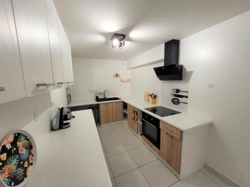 uma cozinha branca com um lavatório e um fogão em KAZANVIL em Saint-Denis